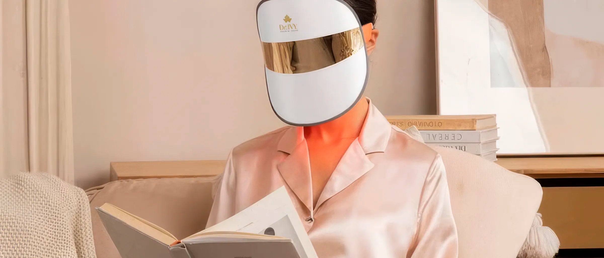 Woman wearing a Dr Ivy Skincare London Regenerative skincare Energy LED Face mask - reading a book